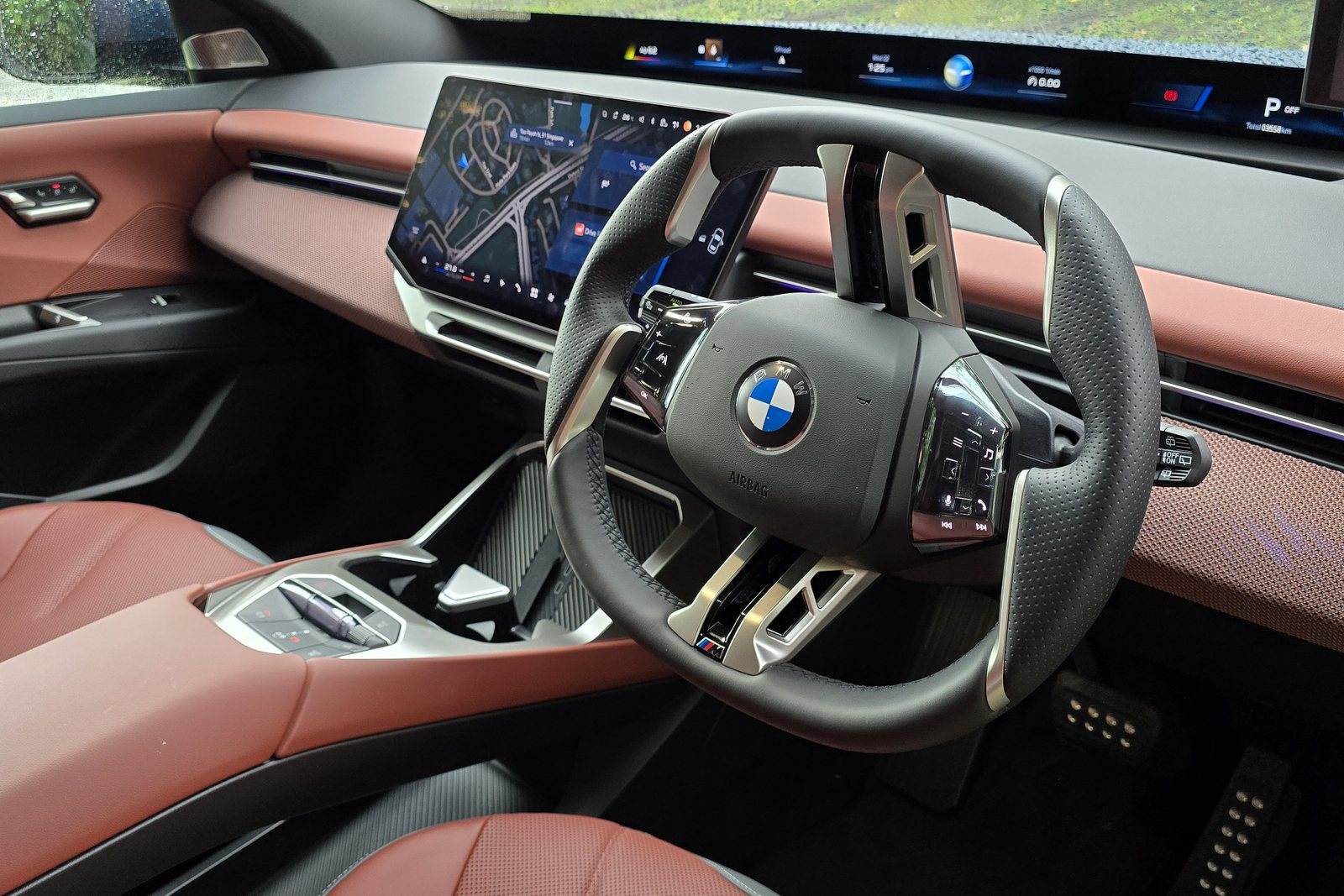 BMW iX3 steering wheel with vertical spokes, squared-off top section and illuminated button panels