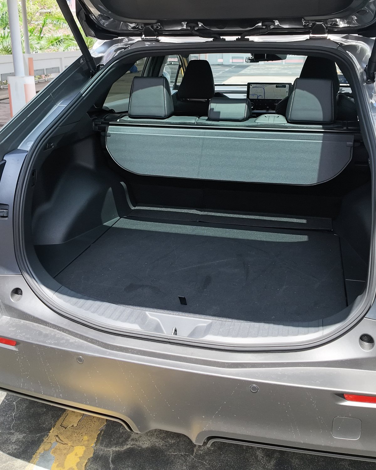 Toyota bZ4X boot open showing a wide, square load bay and the rear seats beyond it