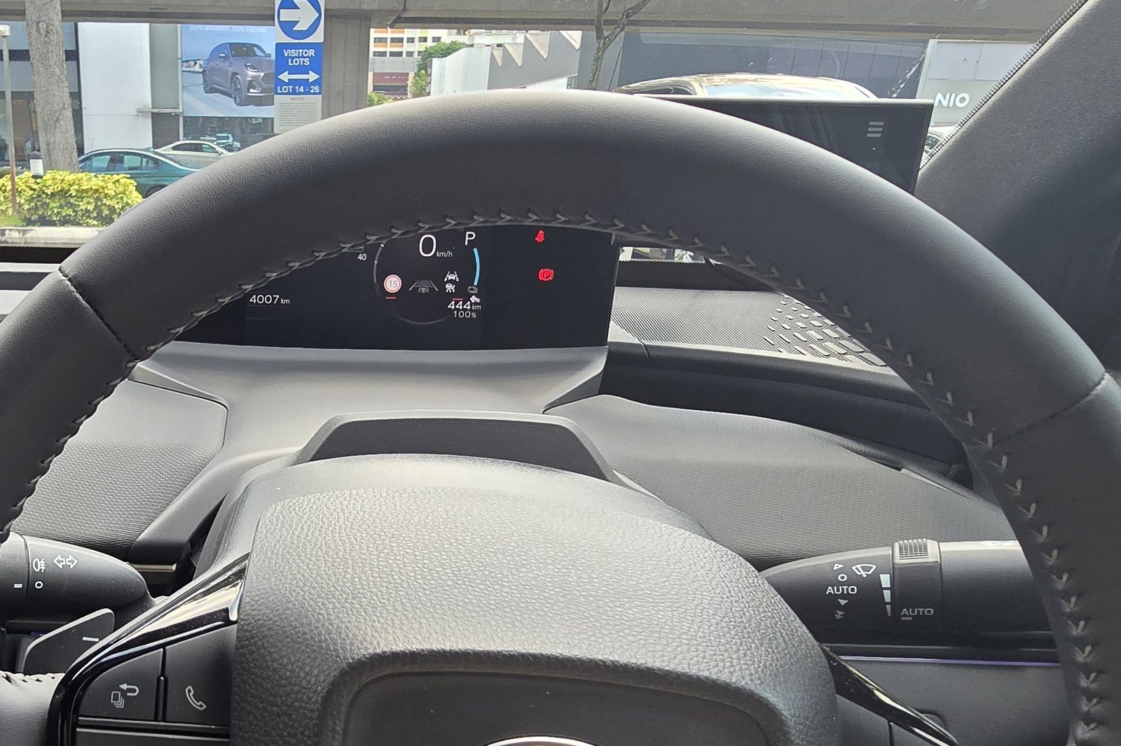 View from the driver's seat of the Toyota bZ4X showing the top of the steering wheel rim cutting across the bottom of the instrument display