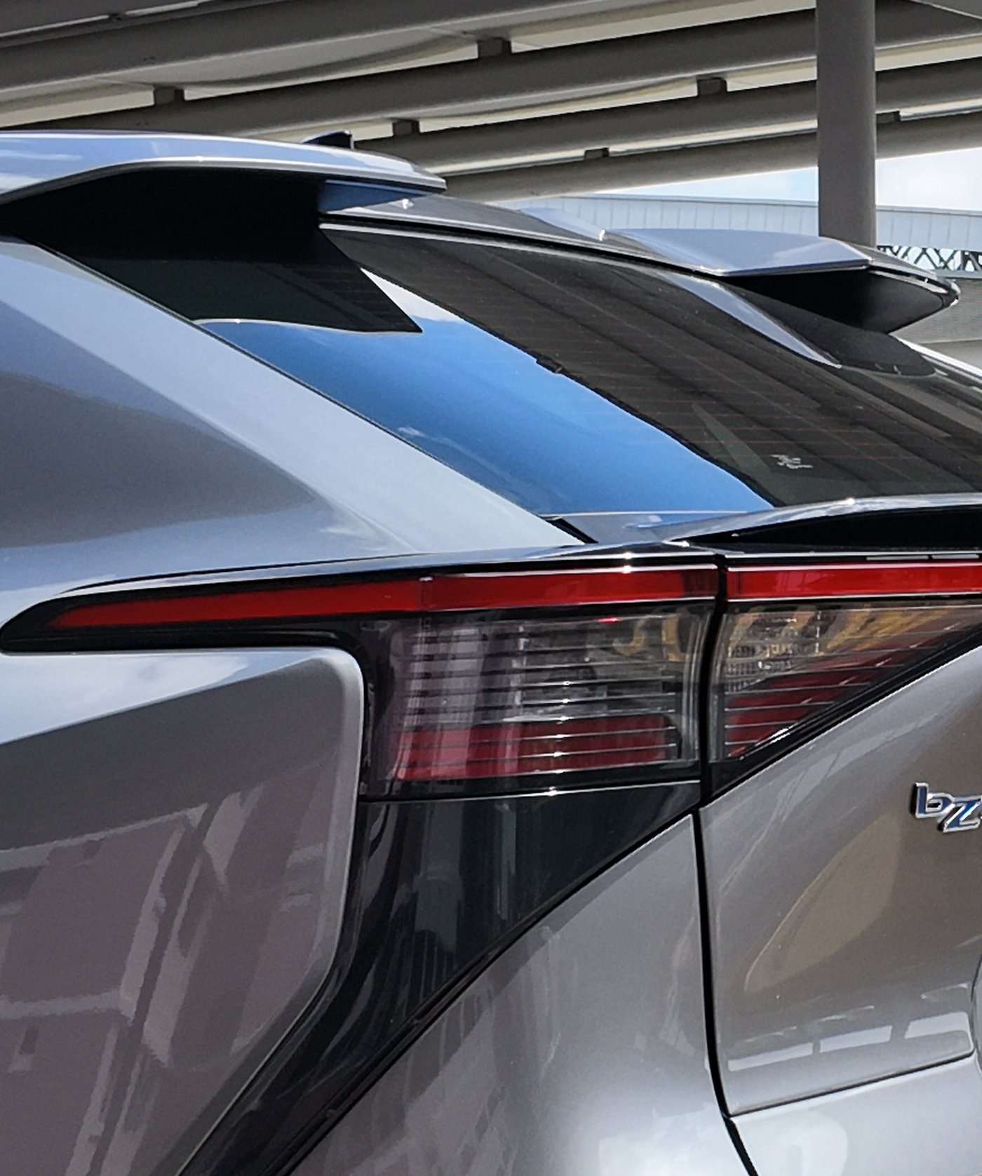 Close view of the Toyota bZ4X tail lamp, full-width light bar, ducktail spoiler and roof spoiler