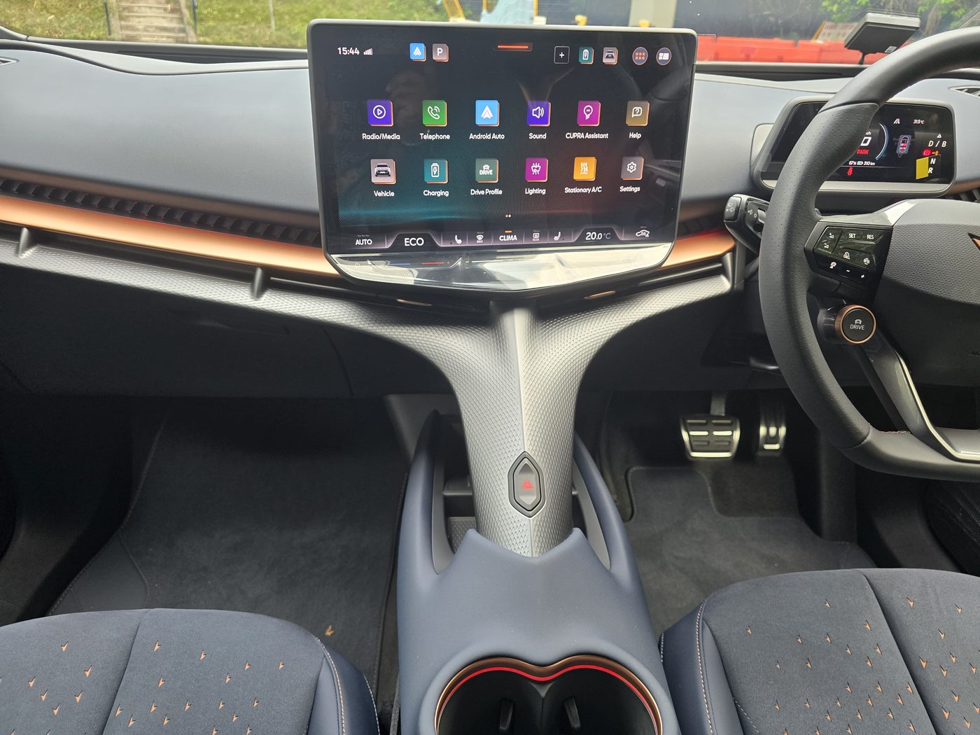 Cupra Tavascan cabin from the driver side showing the angled 15-inch screen, the central spine running from dash to console and the copper trim