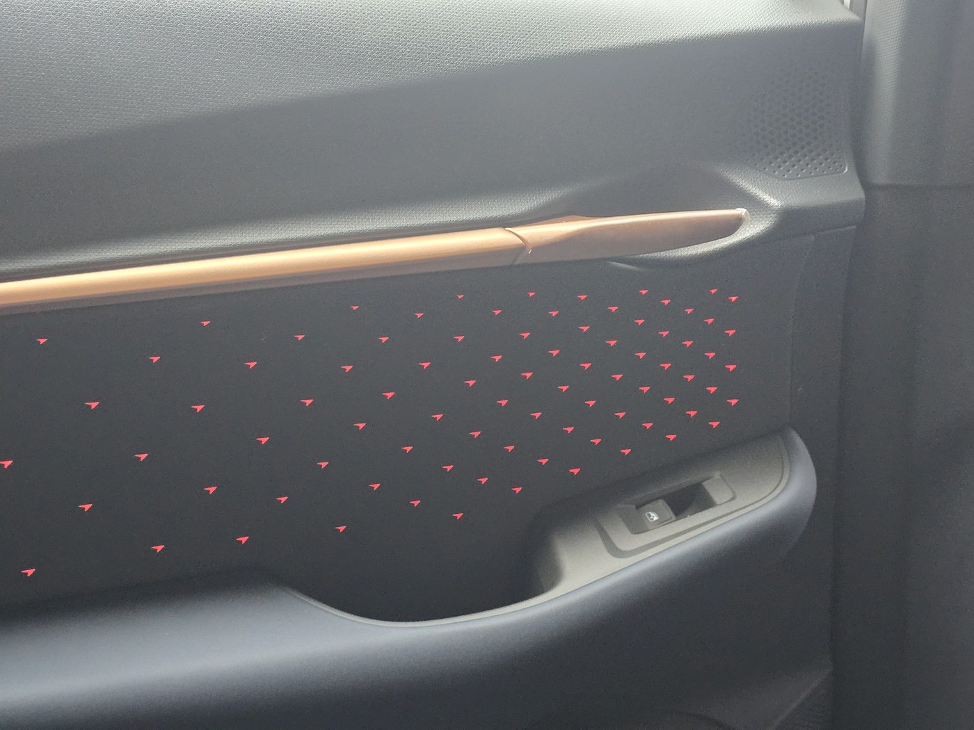 Cupra Tavascan door card with a copper strip and a field of small red ambient lights