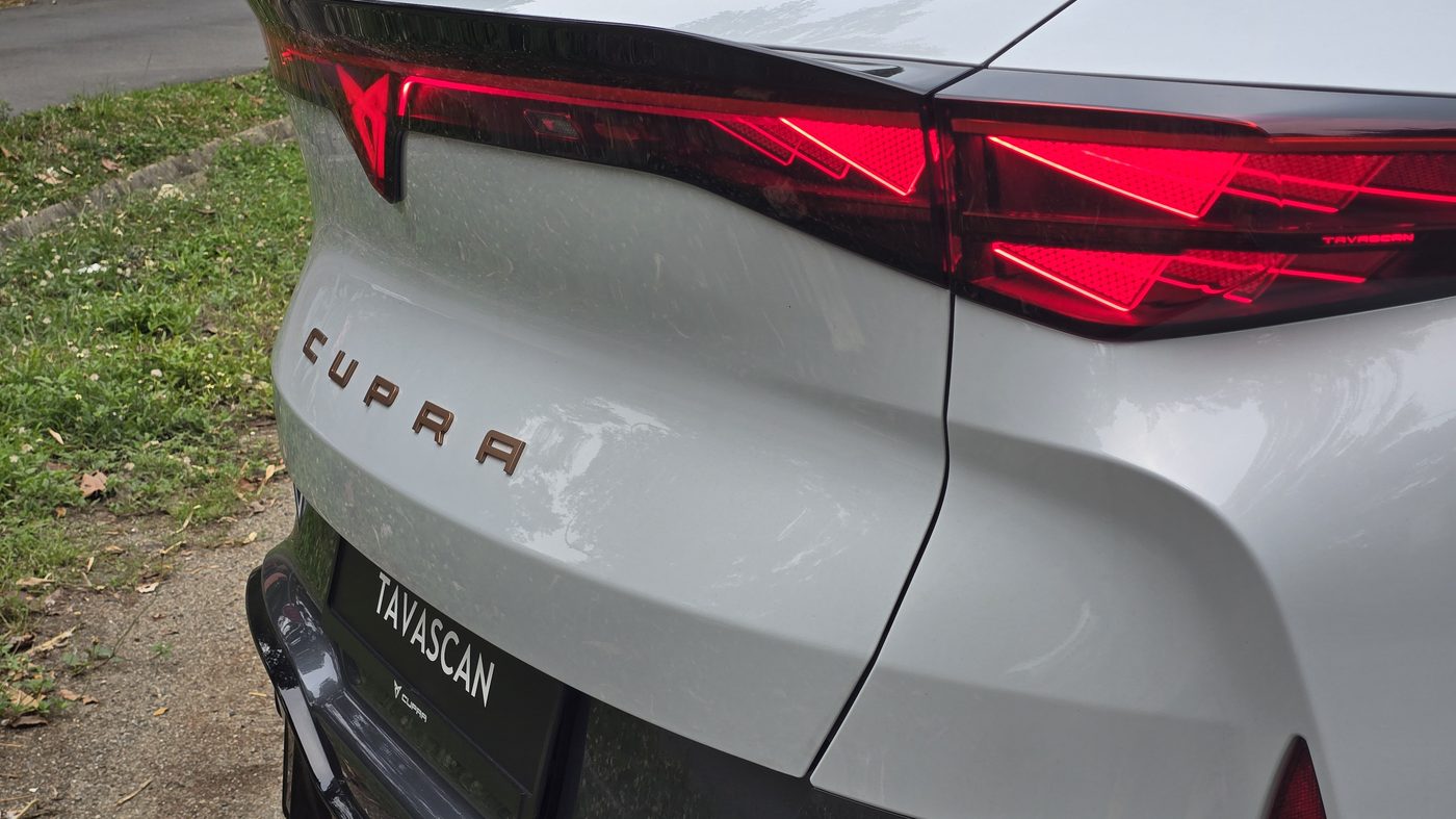 Rear of the Cupra Tavascan with CUPRA lettering across the tailgate and the lit triangular tail light
