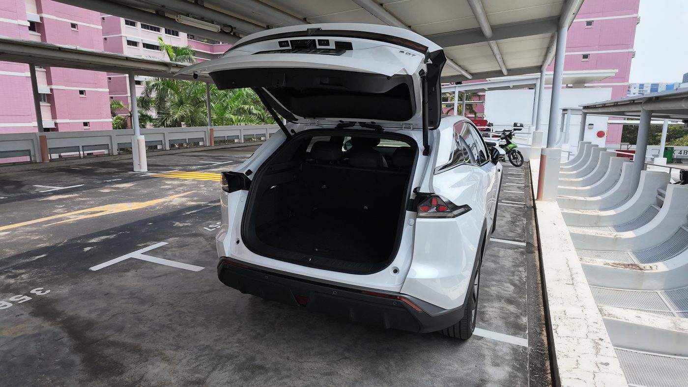 White Deepal S07 with the tailgate open on a rooftop carpark in Singapore