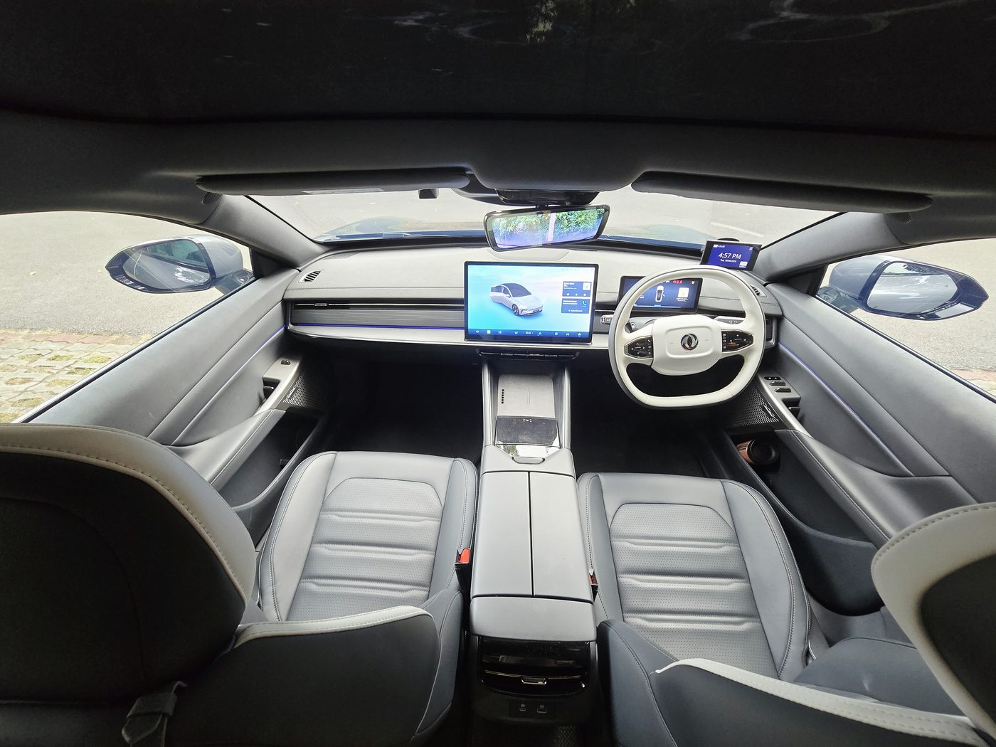 Wide interior view of the Dongfeng 007 cabin from the back seat, showing the panoramic glass roof and twin front seats