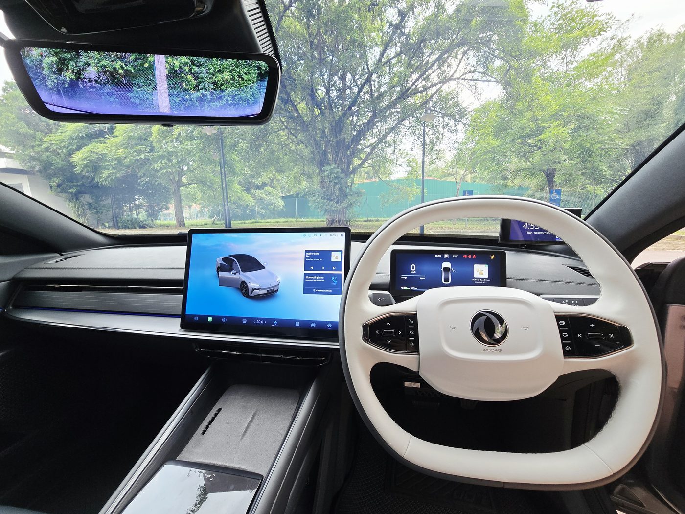 The Dongfeng 007 white two-tone steering wheel with physical buttons, twin screens behind