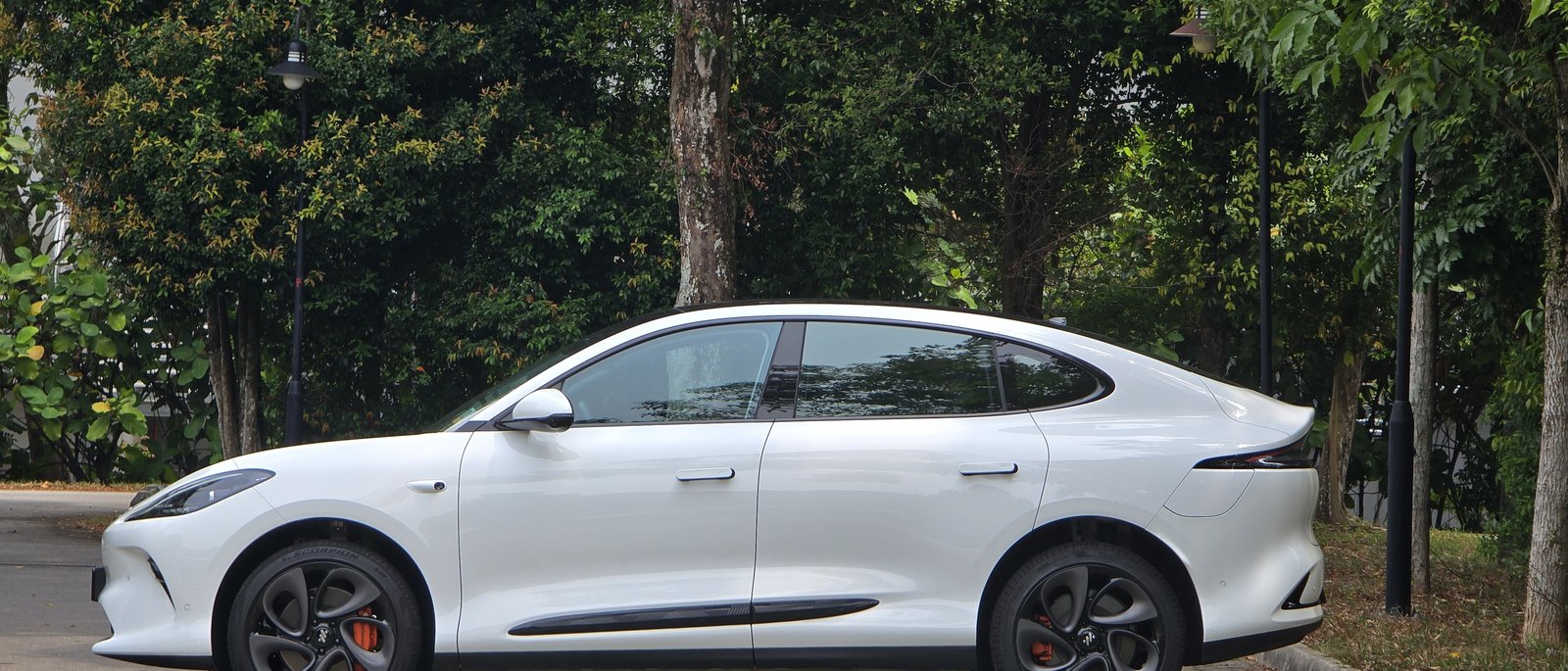 IM6 Performance in Athena White, side profile, parked under trees in Singapore