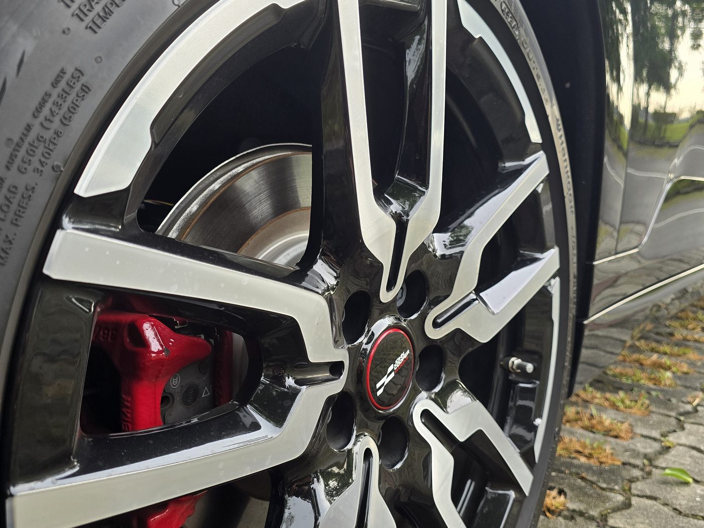 Close-up of the MINI JCW Aceman E's 19-inch two-tone John Cooper Works wheel and red brake caliper
