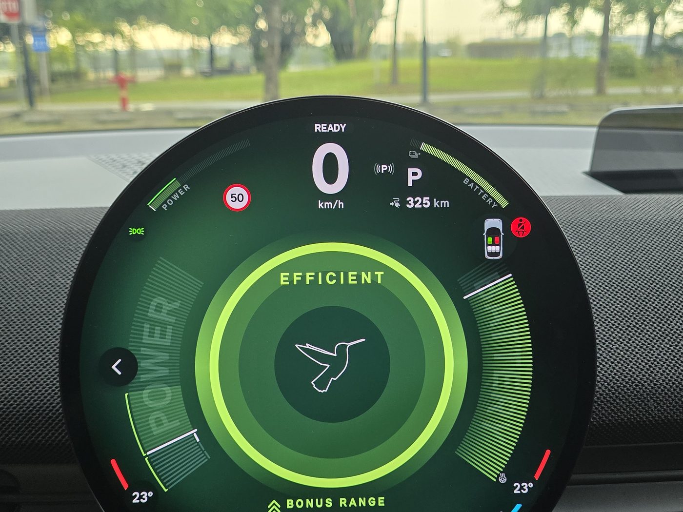 The MINI JCW Aceman E round display in Green mode, showing an Efficient rating, a hummingbird graphic and 325 km of range on a full charge