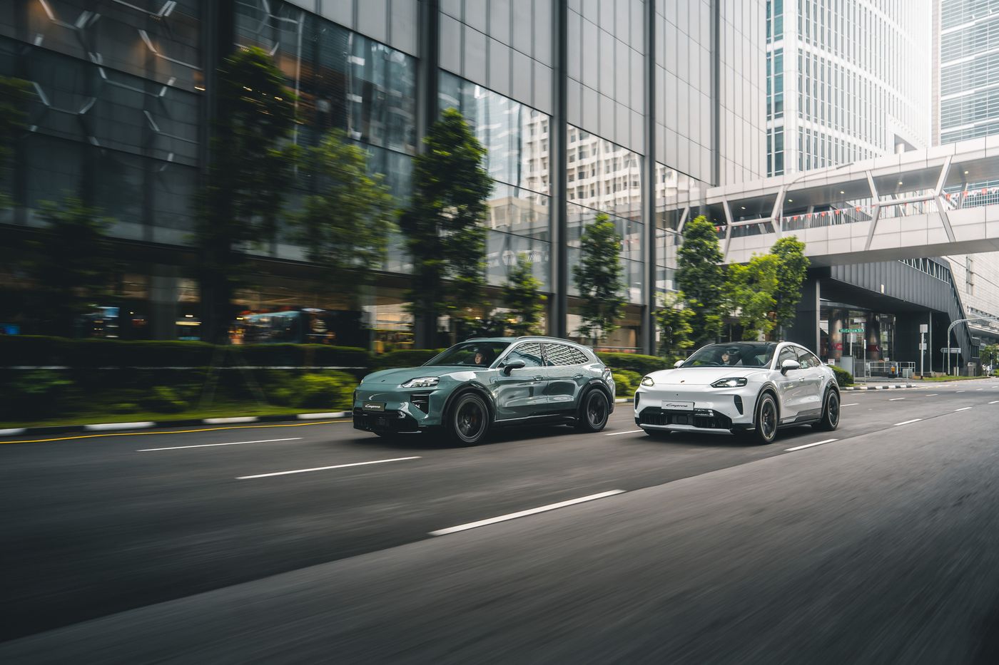 Porsche Cayenne Electric models driving through Singapore's central business district