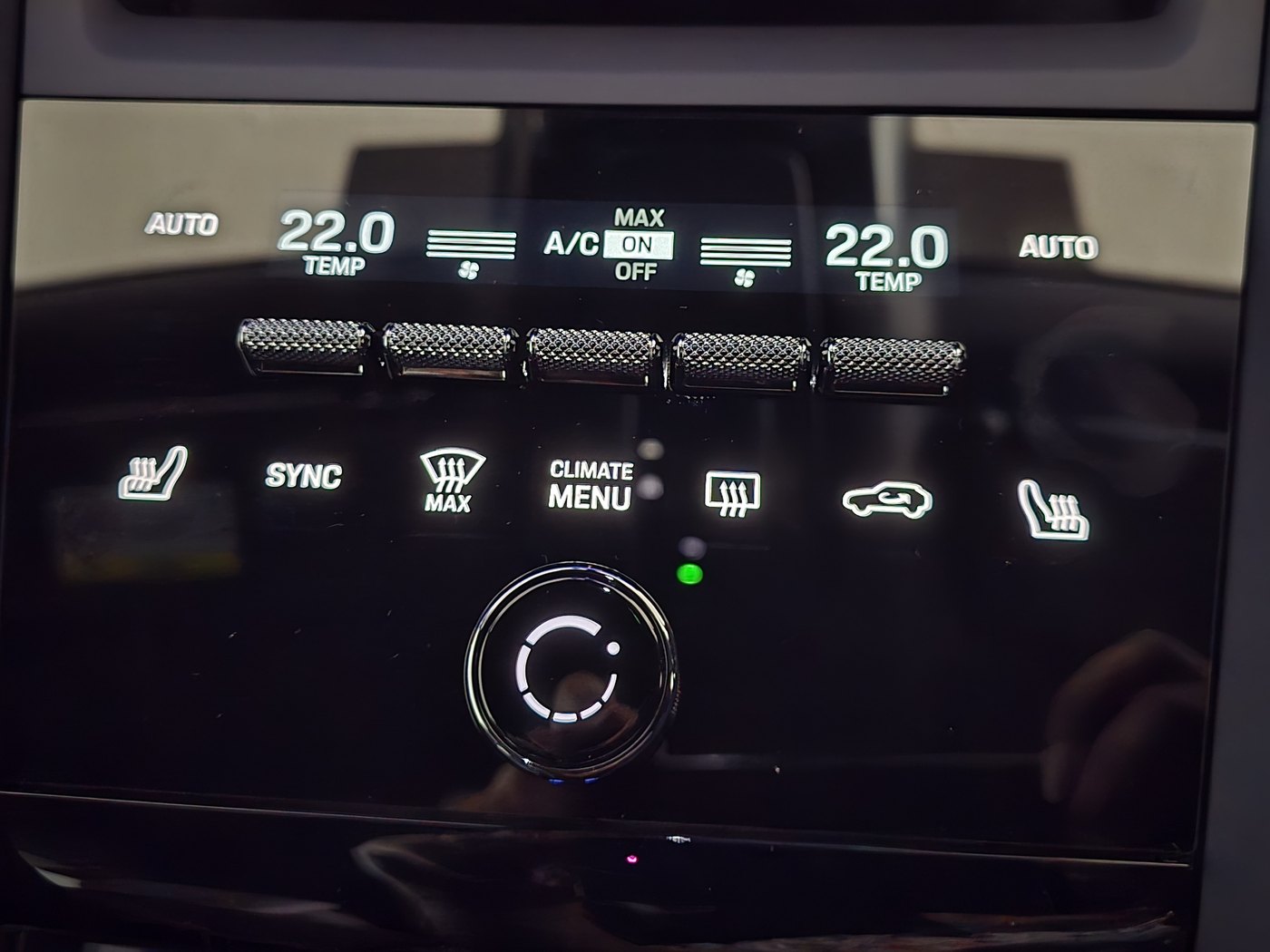 Porsche Macan Electric climate panel with knurled toggle switches, touch icons for seat heating and demisting, and a volume knob