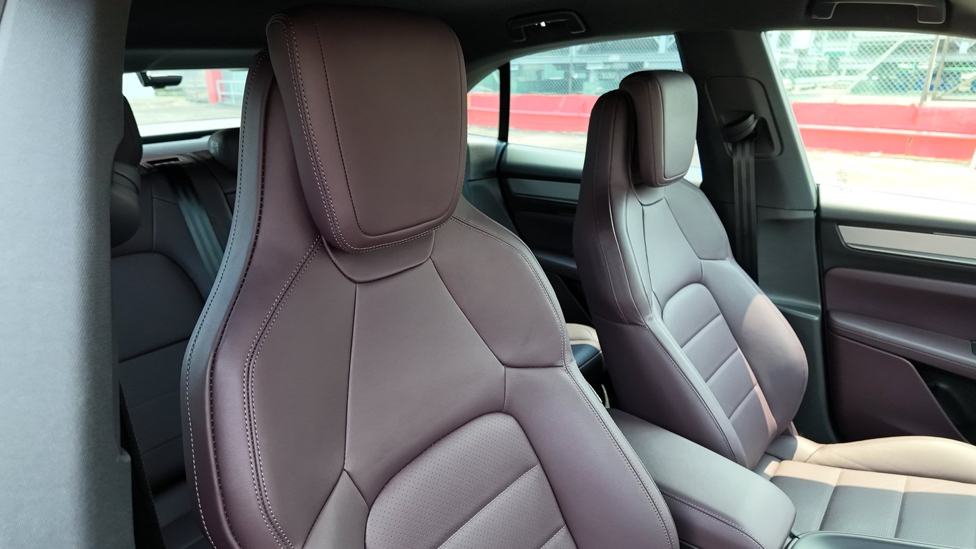 Close view of the Porsche Macan Electric front seats in Bramble leather, showing the stitching and headrests