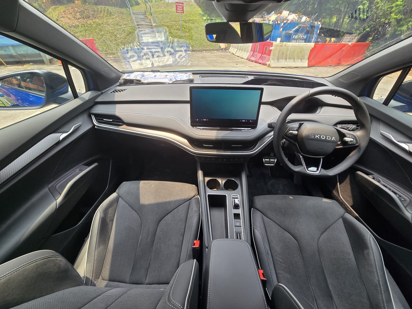 Skoda Enyaq Sportline cabin from the rear seat, showing the Suedia sports seats, the floating 13-inch screen and the two-spoke steering wheel