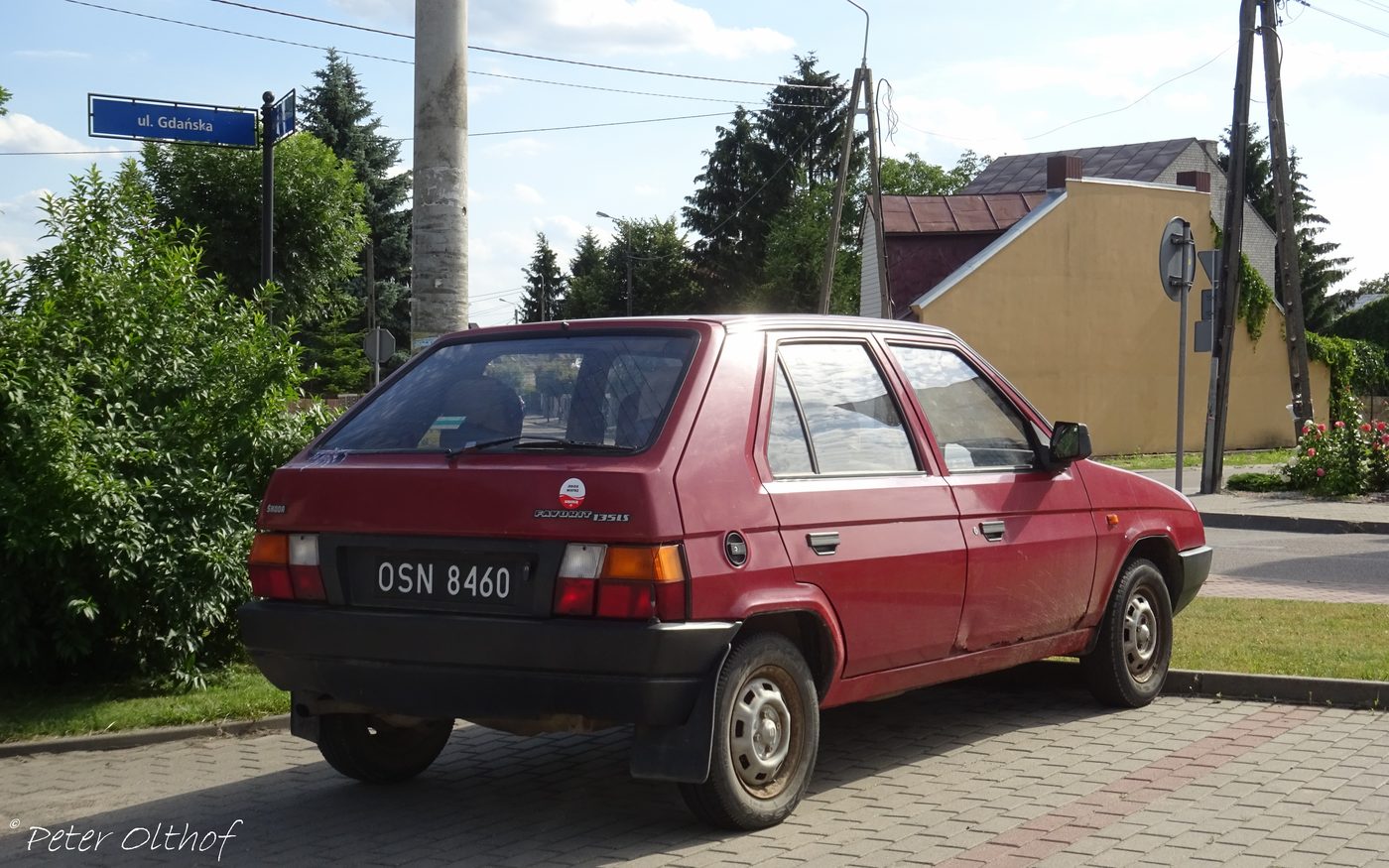 A red Škoda Favorit hatchback parked on a street