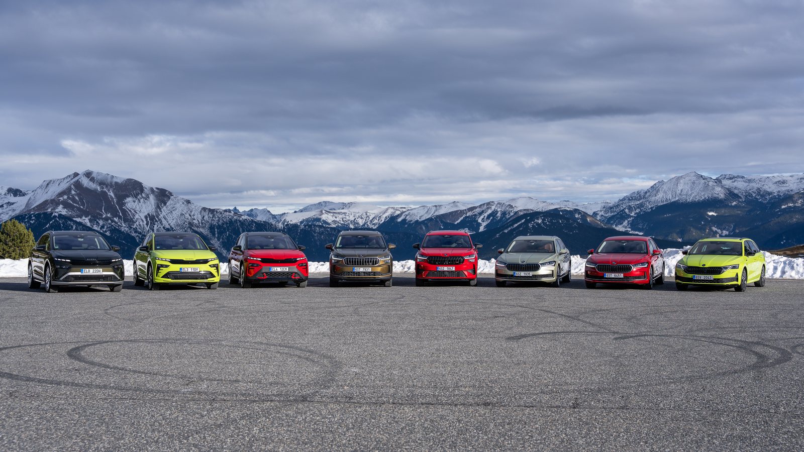 Nine current Škoda models lined up in front of snow-capped mountains