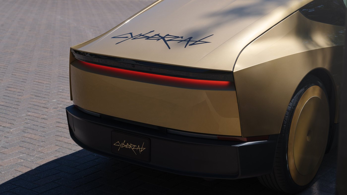 Rear of the Tesla Cybercab showing the full-width red light bar and the Cybercab script on the hatch