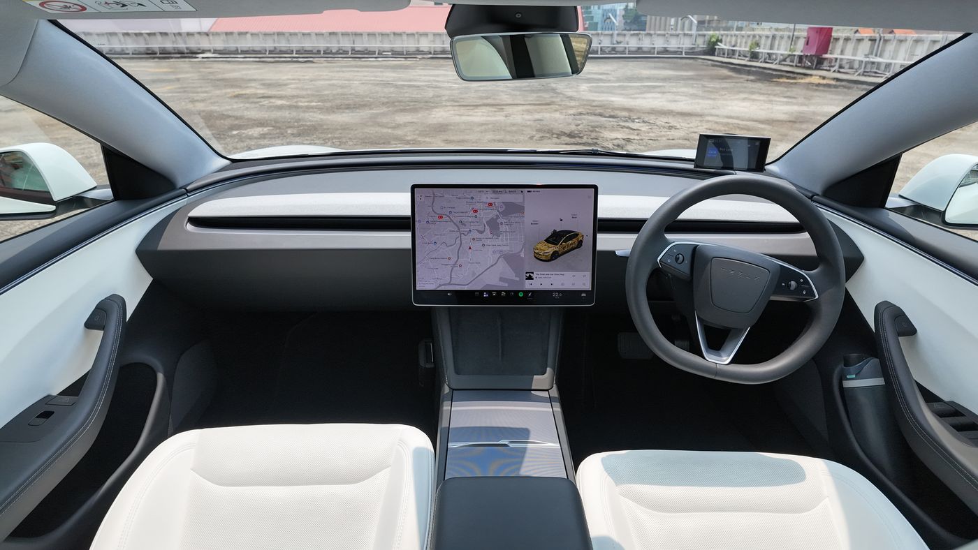 Tesla Model 3 dashboard with white seats, a single centre screen and no instrument cluster